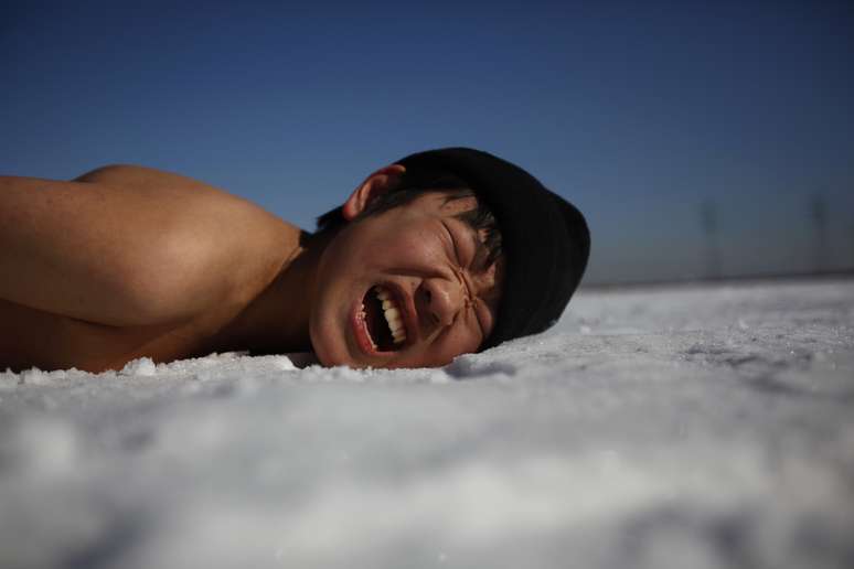 Estudante faz careta ao fazer exercícios deitado na neve. Crianças de 11 a 17 anos se reuniram em Ansan, ao sul de Seul, para um acampamento militar de inverno. O treinamento, que não é obrigatório e é oferecido por fuzileiros navais aposentados, dura entre 4 e 14 dias<br />