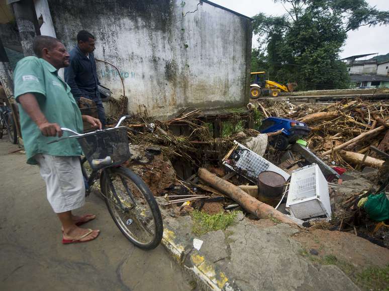 Morador observa estragos provocados pela chuva em Xerém, em Duque de Caxias