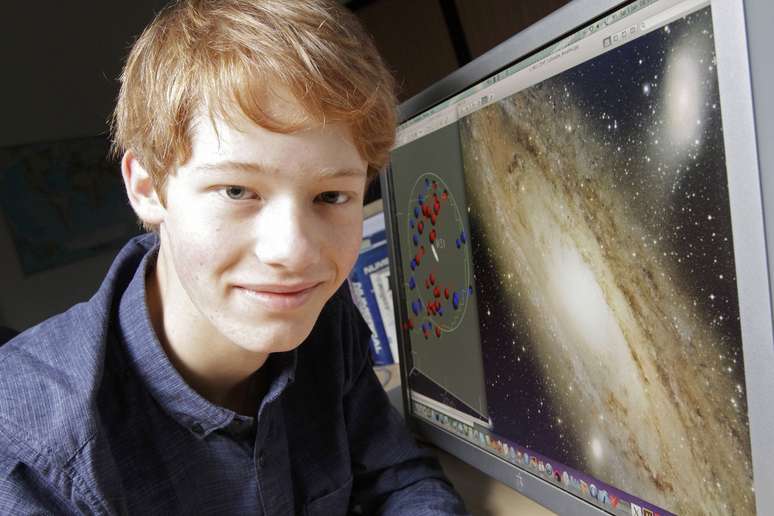 Neil Ibata posa ao lado de computador que exibe sua pesquisa sobre a galáxia de Andromêda em observatório de Estrasburgo