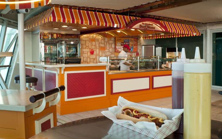 Boardwalk Dog House -  São muitas as opções para os hóspedes do navio Splendour of the Seas, da Royal Caribbean International, que está no Brasil e América Latina nesta temporada. Eles podem escolher desde o tradicional cachorro-quente até lanches mais completos e com outras variedades de carnes, tanto no almoço quanto no jantar (sem taxa extra)<br />