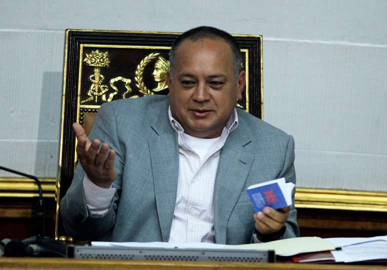 Cabello gesticula com a Constituição venezuelana na sessão parlamentar em que confirmou a ausência de Chávez