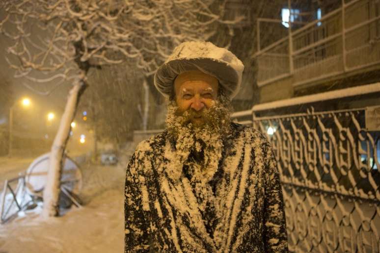Imagem mostra homem judeu coberto de neve em Jerusalém; onda de frio rara atinge a região