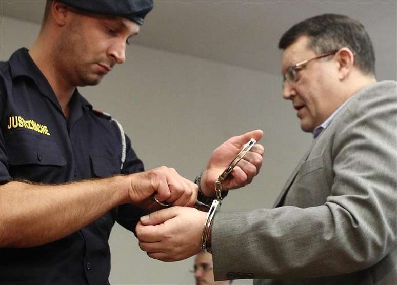 Policial retira algemas do austríaco Gottfried Kuessel (dir.) no tribunal em Viena, em junho de 2012