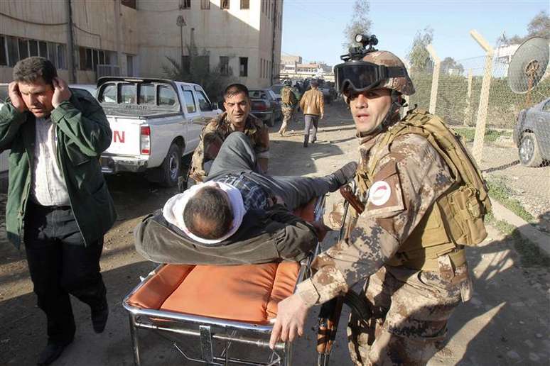 Homem ferido é transportado em maca após explosão de ataque suicida em Kirkuk, a 250 km de Bagdá. 16/01/2013