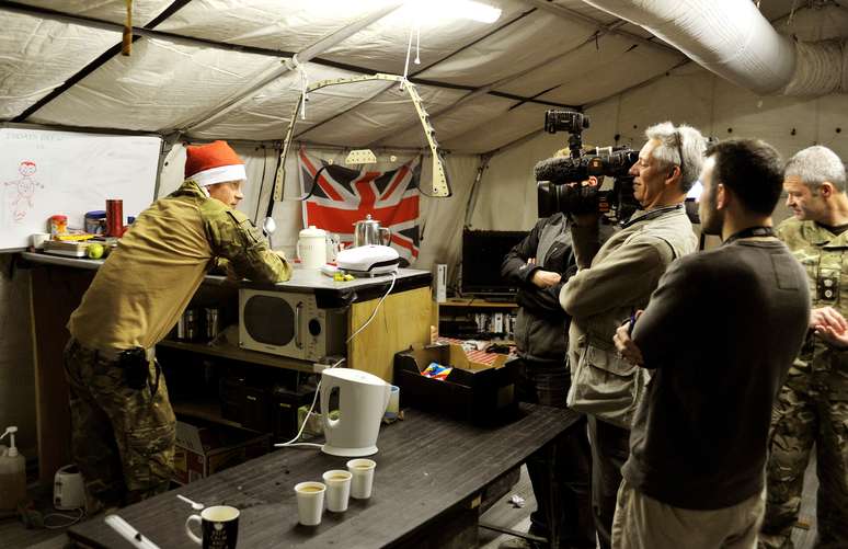 Imagem do dia 12 de dezembro mostra o príncipe Harry conversando com uma equipe de TV enquanto preparava o próprio café da manhã no Afeganistão<br />