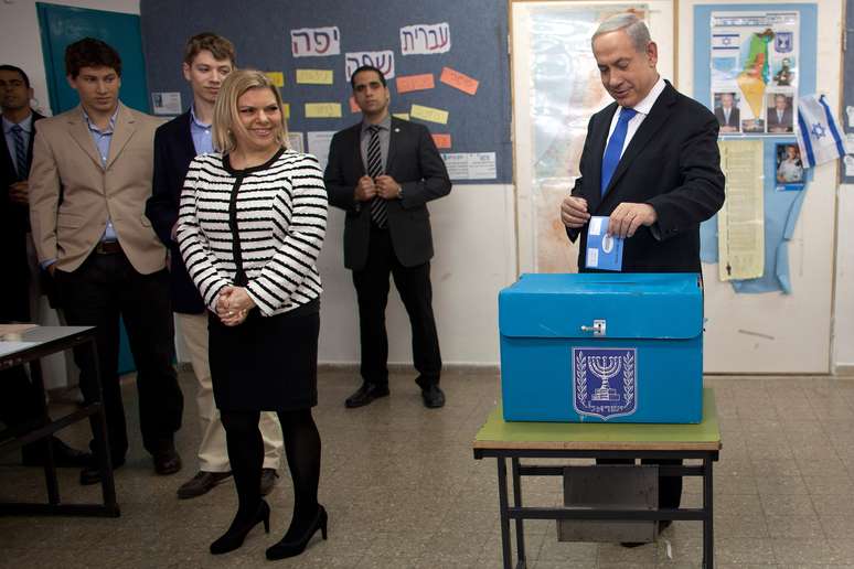 O premiê israelense, Benjamin Netanyahu, deposita seu voto ao lado da esposa Sara