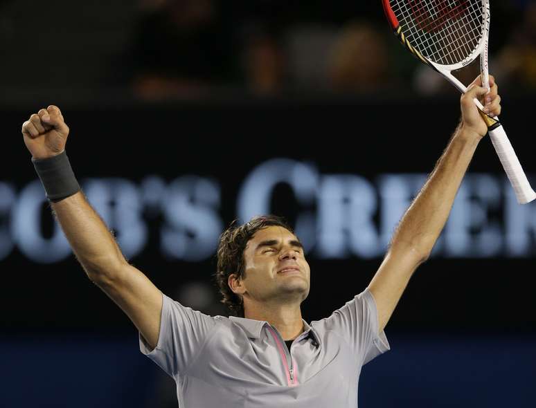 Roger Federer ergue os braços para comemorar a vitória sobre Jo-Wilfried Tsonga, na manhã desta quarta-feira. O suíço bateu o francês por 3 sets a 2, com parciais de 7/6 (7-4), 4/6, 7/6 (7-4), 3/6 e 6/3, e avançou à semifinal do Aberto da Austrália pelo décimo ano seguido