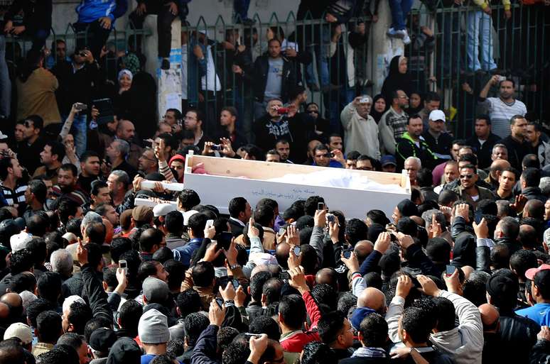 Vítima é carregada em funeral coletivo dos mortos nos enfrentamentos de sábado no Egito