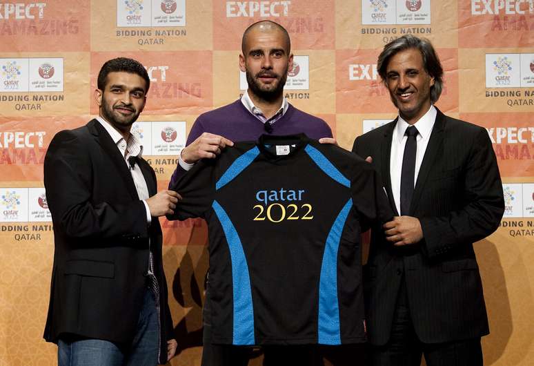 Em foto de 2010, Guardiola posa ao lado de Hassan Al-Thawadi (à esq.), chefe da campanha do país à sede da Copa, e do xeque Hamad bin Khalifa bin Ahmed Al Thani, presidente da federação de futebol do país