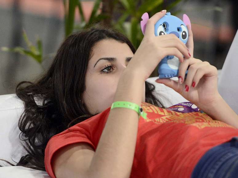 Campuseira mexe em seu celular com capa representando Stitch, personagem do filme de animação <i>Lilo & Stitch</i>