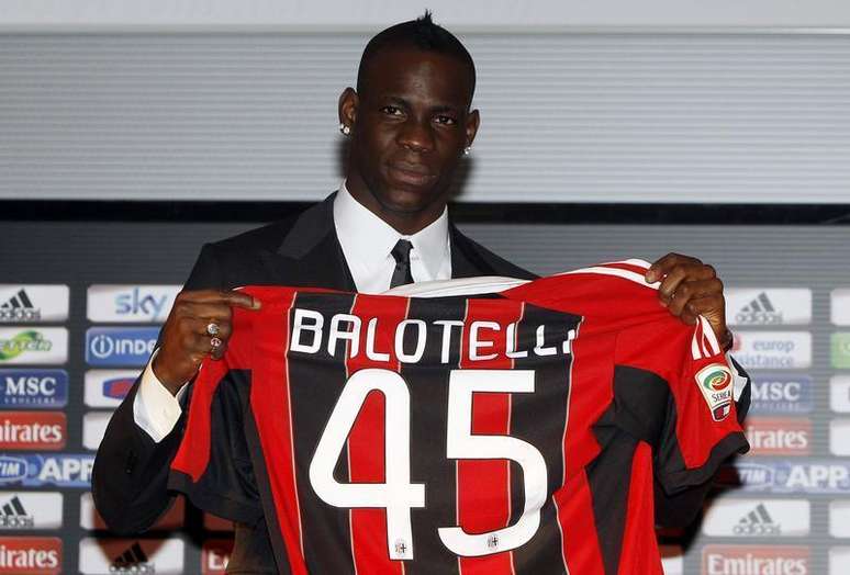 Atacante italiano Mario Balotelli posa para fotos com sua nova camisa do AC Milan, na Itália. Balotelli está aliviado por deixar a Inglaterra e se ver livre da imprensa, do clima, da comida e até mesmo das regras de trânsito do país, disse o excêntrico jogador ao ser apresentado pelo Milan na última sexta-feira. 01/02/2013