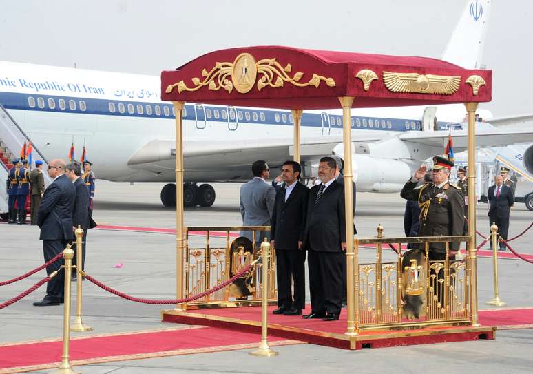 O presidente egípcio, Mohammed Mursi (dir.), recebeu Adhmadinejad em aeroporto no Cairo