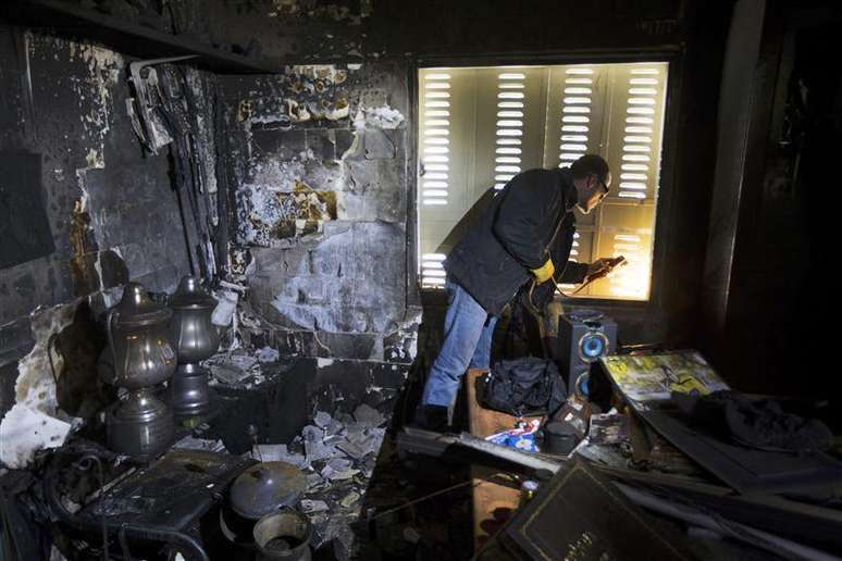 Funcionário conserta janela em sala danificada por um suposto incêndio criminoso na sede do time israelense Beitar Jerusalém, em Jerusalém. 08/02/2013