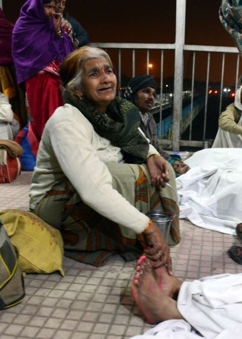 Idosa chora a morte de um parente em uma estação de trem em Allahabad