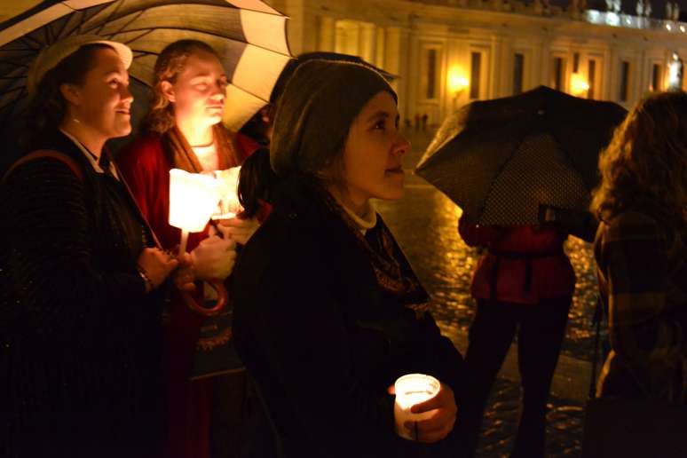 <p>Fiéis reuniram-se sob chuva na Praça de São Pedro na noite do dia em que, pela quarta vez na história, um papa renunciou</p>