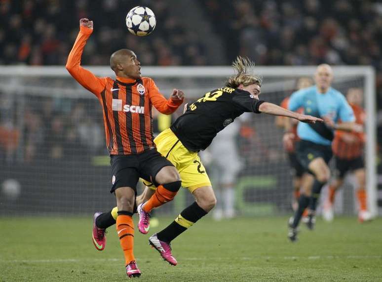 O brasileiro do Shakhtar Donetsk Douglas Costa disputa bola com o jogador do Borussia Dortmund Marcel Schmelzer durante empate dos times pela Liga dos Campeões.