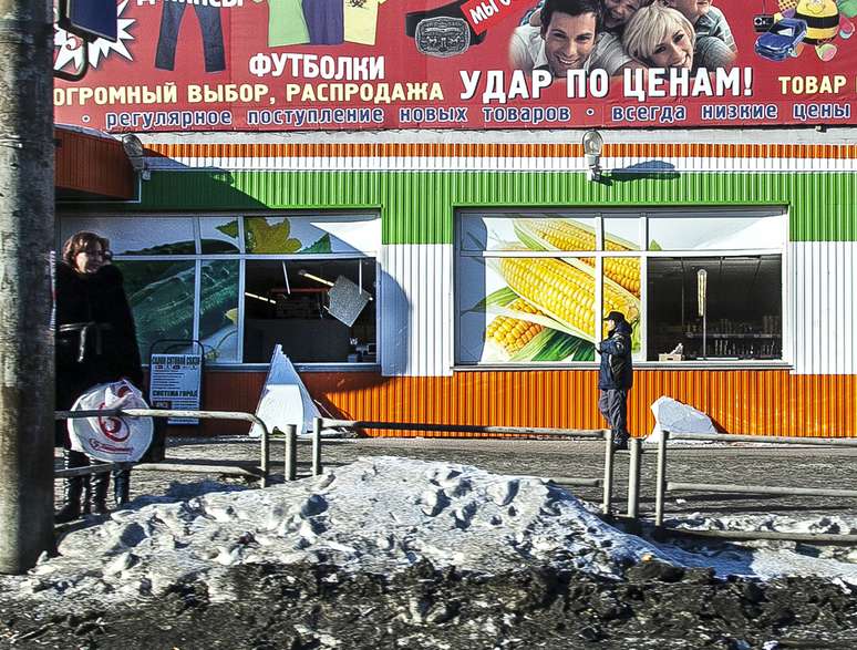 <p>Moradores caminhavam em frente a uma loja, que foi danificada pela queda do meteorito</p>