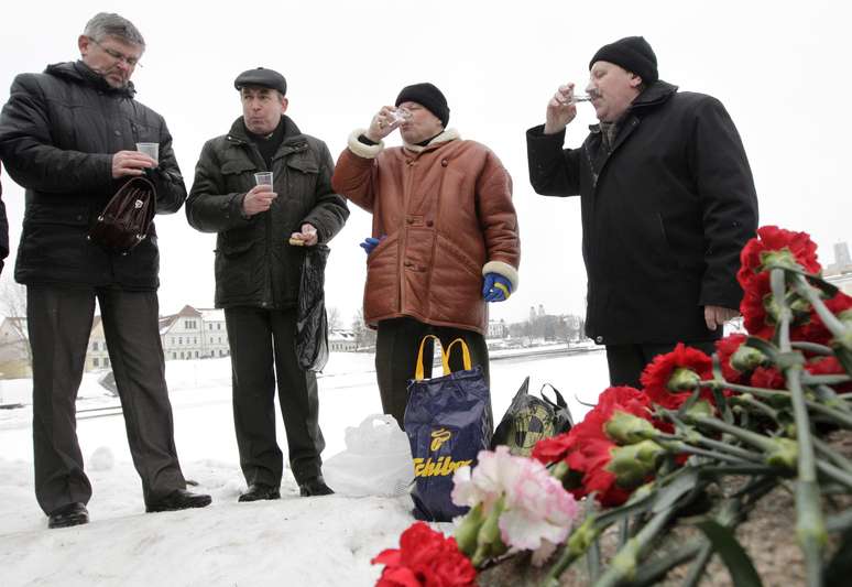 <p>Bielorrussos bebem vodca em cerimônia que homenageia soldados mostos na guerra no Afeganistão. Nesta sexta, o país lembra junto com outras antigas nações soviéticas o 24º aniversário da retirada das tropas do Afeganistão, onde lutaram por dez anos</p>