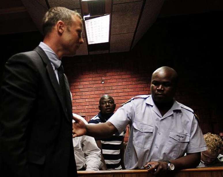O sul-africano Oscar Pistorius (centro) é escoltado pela polícia em Pretoria, África do Sul. 15/02/2013