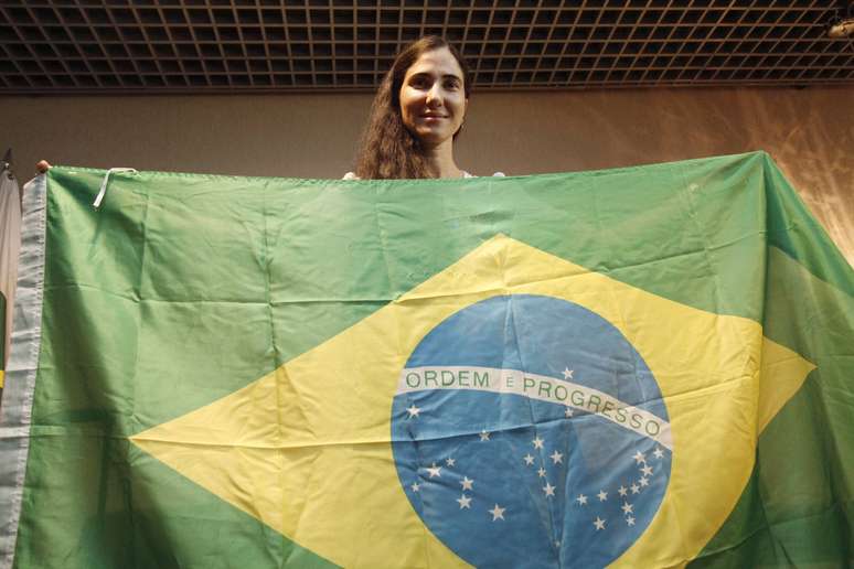 A blogueira dissidente cubana Yoani Sánchez posa com a bandeira brasileira após desembarcar no aeroporto de Guararapes, em Recife (PE)
