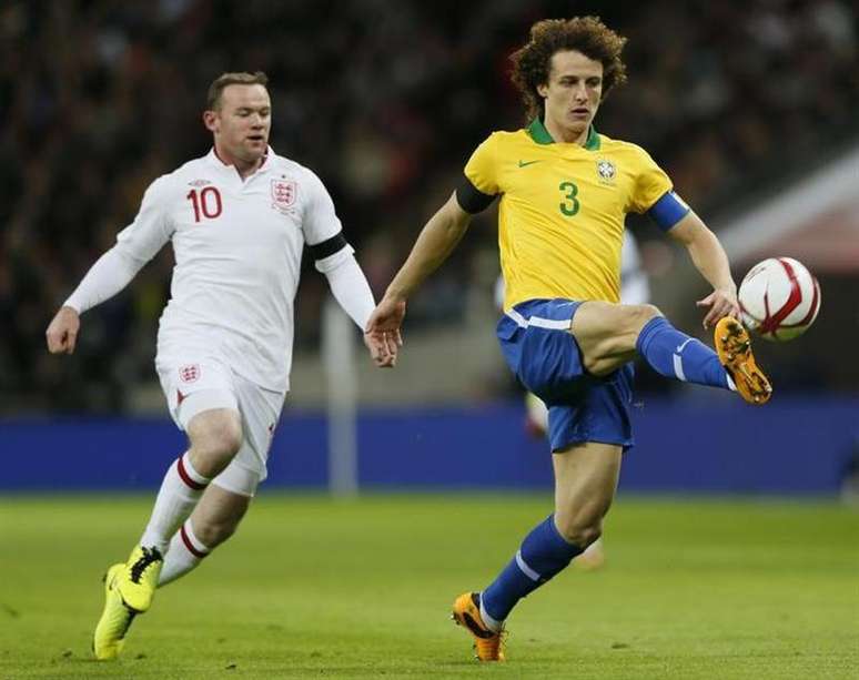 David Luiz (D) disputa lance em amistoso da seleção brasileira contra a Inglaterra, em 6 de fevereiro. O zagueiro disse que está pronto para jogar no meio-campo, se for preciso.