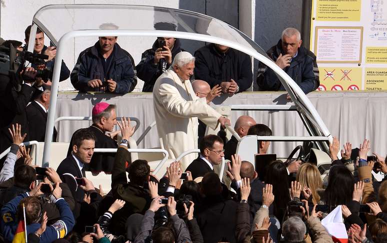 <p>A bordo de seu tradicional papamóvel, Bento XVI saúda fiéis reunidos na Praça São Pedro antes de comandar a última audiência geral de seu Pontificado</p>