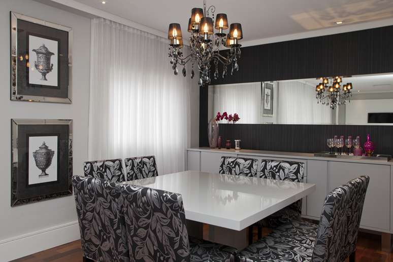 Na sala de jantar, as cores preta e branca predominam. A mesa e o buffet brancos contrastam com as cadeiras estampadas
