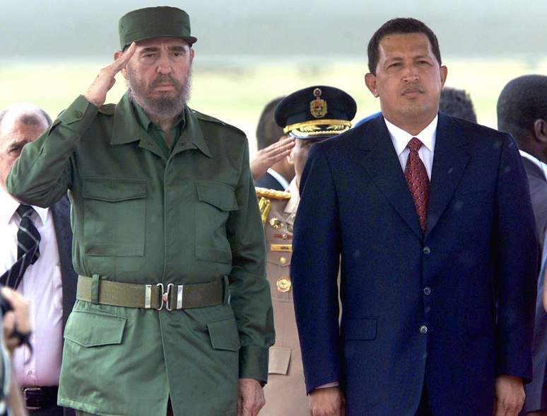 Presidente cubano Fidel Castro faz saudação durante a execução do hino nacional em sua primeira visita à Venezuela durante o governo Chávez, em 26 de outubro de 2000