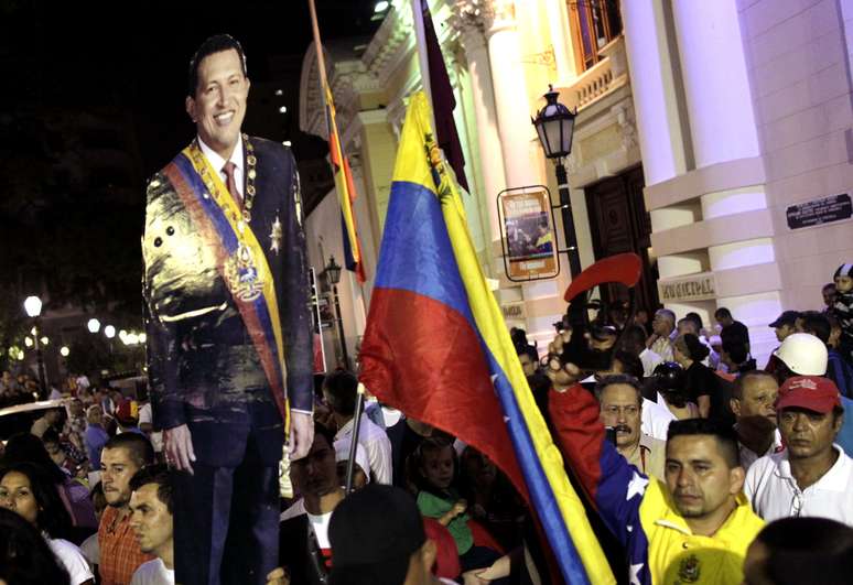 Clima é de tristeza nas Praça Bolívar, em Caracas, onde venezuelanos carregam imagens de Hugo Chávez