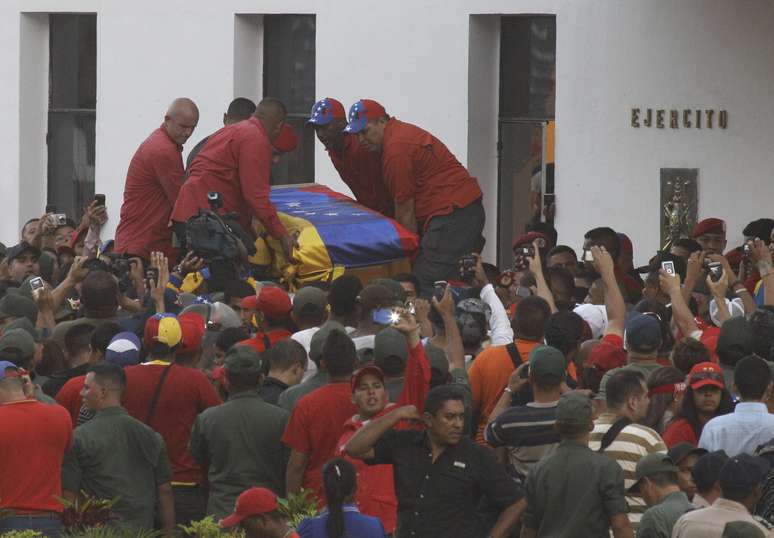 Caixão com o corpo de Chávez é retirado do carro na Academia Militar, após um cortejo de seis horas que reuniu milhares de pessoas pelas ruas de Caracas