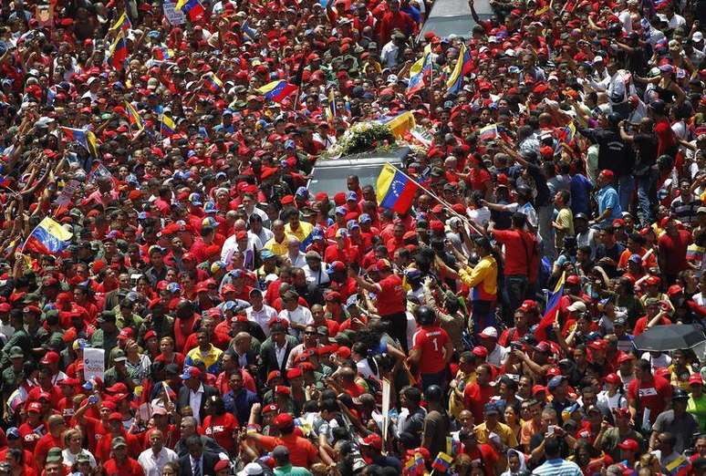 <p>Caixão é conduzido pelas ruas de Caracas em meio a uma multidão de apoiadores</p>