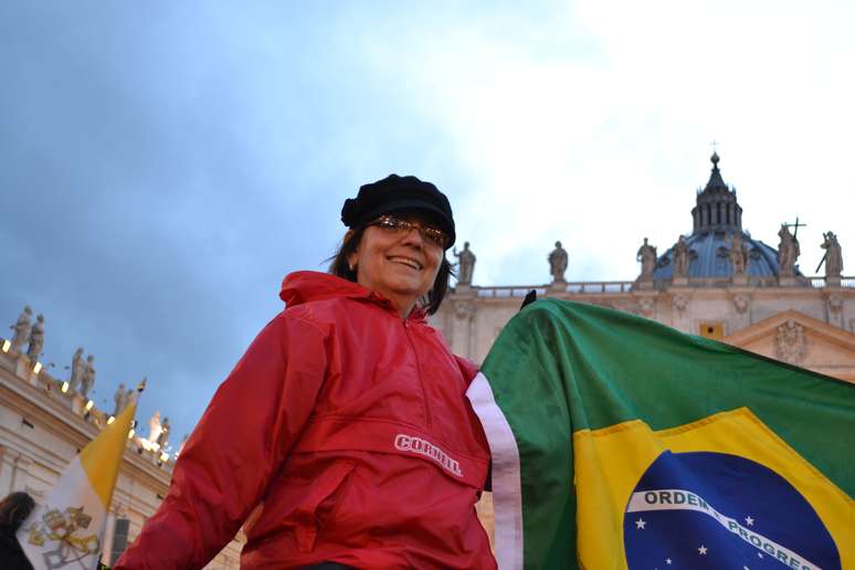 <p>Enrolada em uma bandeira do Brasil, Kathya Zanardi disse que esse momento 'é o máximo para a fé católica'</p>