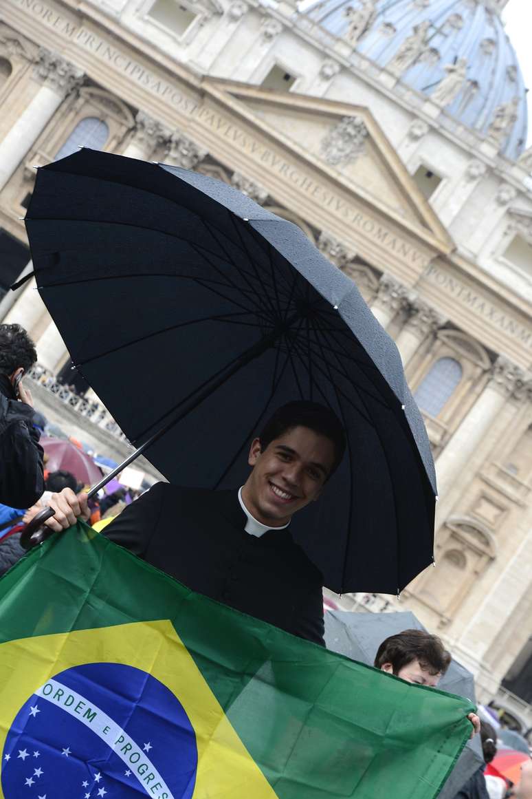 <p>Padre brasileiro segura bandeira do País na Praça São Pedro, na Cidade do Vaticano</p>