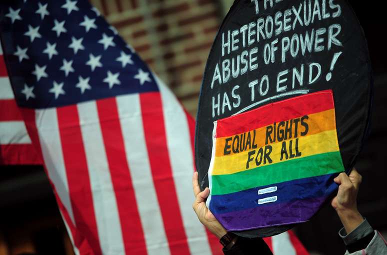 <p>Apoiadores acampados do lado de fora da Suprema Corte, em Nova York, exibem cartaz: 'o abuso de poder dos heterossexuais tem que acabar! Direitos iguais para todos'</p>