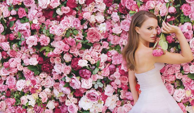 <p>Em outra imagem, Portman foi fotografada em meio a uma parede coberta por rosas</p>
