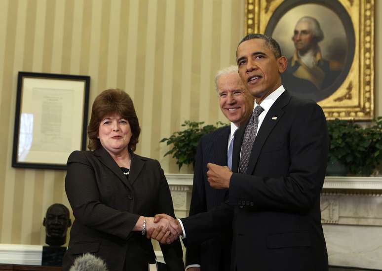 O vice-presidente Joe Biden conduziu o juramento de posse de Julia Pierson ao lado do presidente Barack Obama
