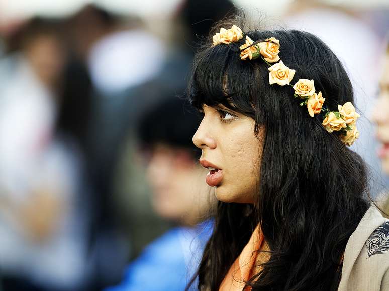 Público que esteve no primeiro dia do Lollapalooza Brasil 2013, no Jockey Club de São Paulo, usou diferentes acessórios. Apesar da chuva, as pessoas não descuidaram do visual. Na imagem, menina optou por uma coroa de flores de cor laranja