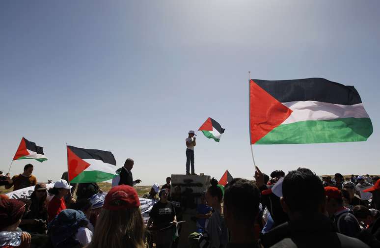 Ativistas seguram bandeiras da Palestina durante comemoração do "Yum al Ard"