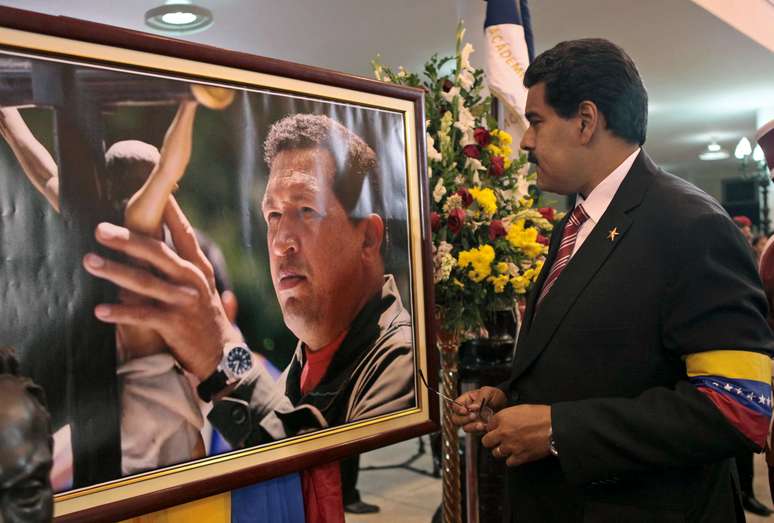 <p>Nicolas Maduro observa quatro de Hugo Chávez em imagem do dia 8 de março</p>