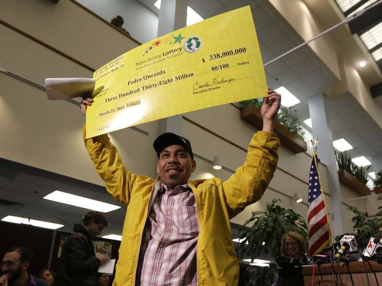 Quezada exibe o cheque simbólico do prêmio milionário da Powerball no dia 26 de março de 2013