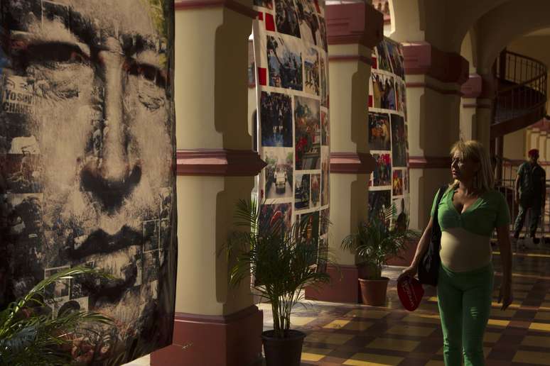 Mulher passa por mural com a imagem de Chávez no forte militar
