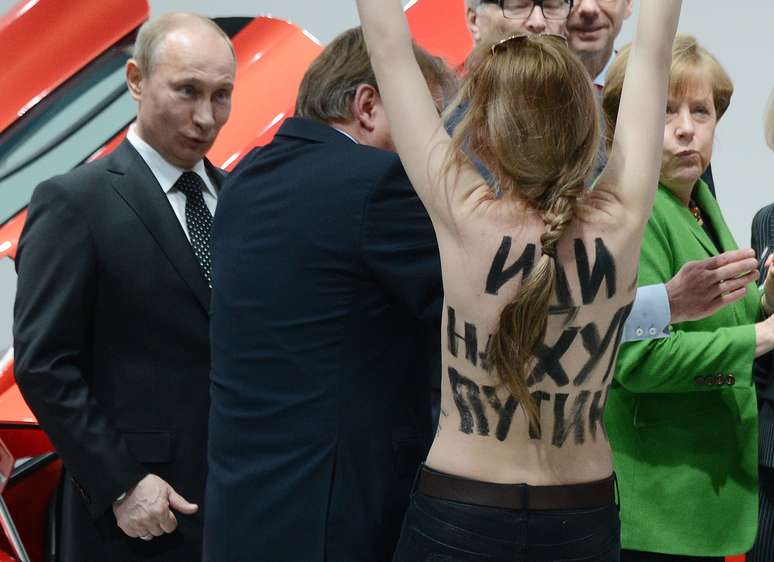 Putin observa jovem ativista protestar durante sua visita à Feira de Hannover