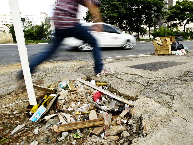 <p>Pedestre salta por cima de um buraco na cal&ccedil;ada da avenida Engenheiro Lu&iacute;s Carlos Berrini, em S&atilde;o Paulo</p>