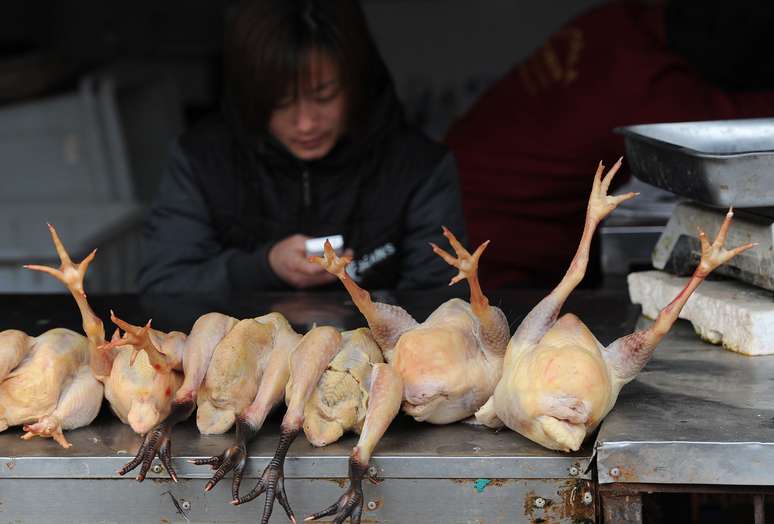 Chinesa trabalha em mercado de frango, em Hefein, que está para ser fechado por causa da gripe aviária