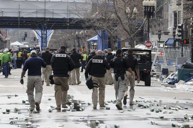<p>Agentes de segurança percorrem o local onde aconteceu a explosão em Boston</p>