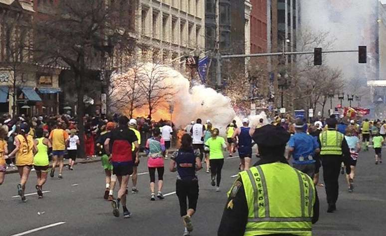 <p>Corredores se dirigem ao final da maratona de Boston no momento da explosão</p>