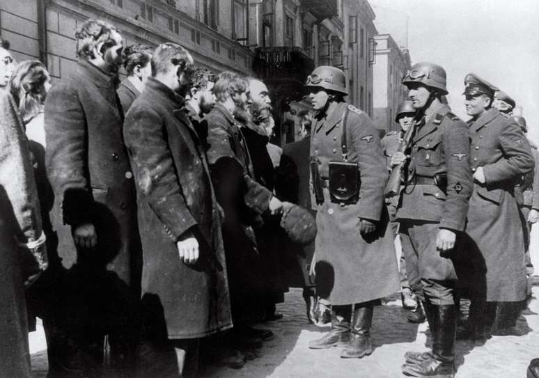 Imagem de 1943 mostra soldados nazistas alemães questionando judeus após o levante do Gueto de Varsóvia