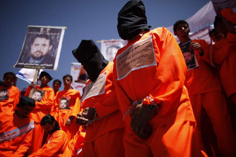 <p>Ex-prisioneiros de Guantánamo usam capuzes para exigir a libertação de outros detidos durante protesto</p>