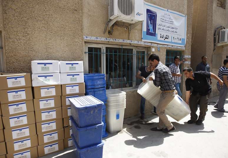 Oficiais da comissão eleitoral iraquiana preparam urnas para eleições, marcadas para sábado