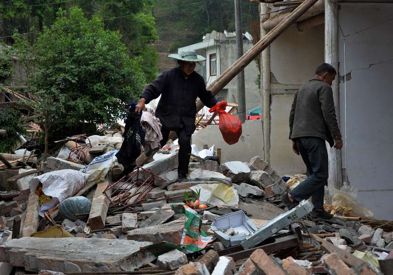 Moradores de Lushan procuram pertences em meio aos destroços de sua casa, que foi destruída pelo tremor